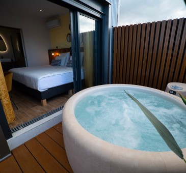 Chambre Bananier avec jacuzzi : Supérieure
Bienvenu dans votre chambre Bananier de 14 m2 + 10 M2 de terrasse avec jacuzzi privé et situé au 2e étage. Ambiance exotique et relaxante. Prélassez-vous et savourez cette bulle de bien-être aux nuances douces et naturelles. Son lit King Size et sa salle de bain moderne aux teintes minérales apportent une touche de confort supplémentaire qui sublimeront votre séjour.
En savoir plus
Reserver au meileur prix